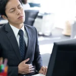 腹部に違和感を感じる男性